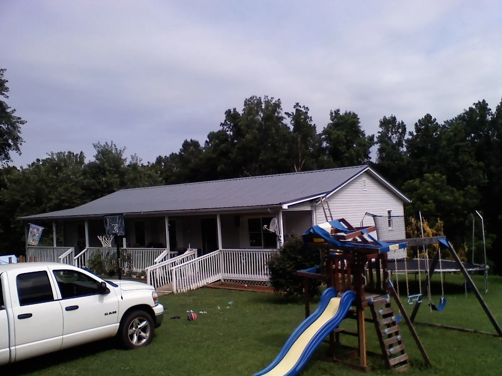 Dark metal roof on a country home with a full length front porch in Gardiner