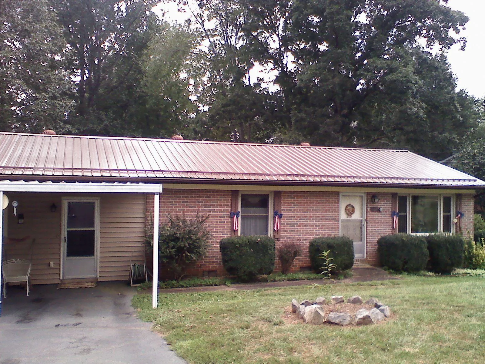 Bronze metal roof and carport on a brick ranch home — Roof Repair work by our crew in Gardiner